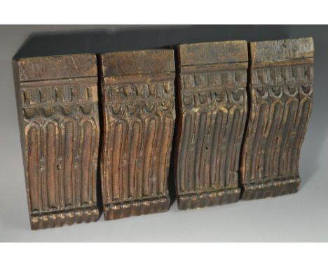 A set of four 16th century oak architectural corbels, each carved with a debased dental frieze above flutes, 20.5cm long, 8.5