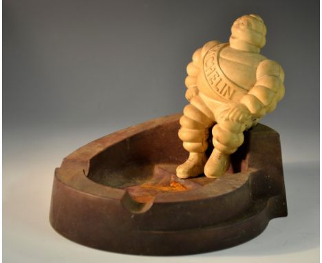 Advertising - a Michelin Man 'Bibendum' ashtray, he sits on the brown Bakelite reservoir, wearing a branded sash, 12cm high, 
