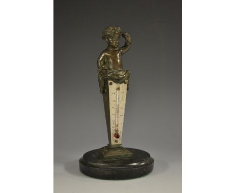 A late 19th century bronze desk thermometer, crested by a Bacchic infant, silvered scale, alcohol thermometer, circular marbl