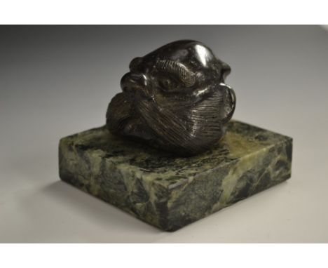A dark patinated bronze mounted desk weight, as the head of a walrus, square marble base, 7.5cm wide 