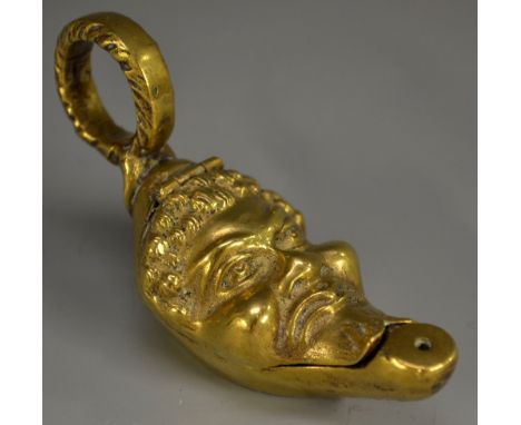A 19th century gilt brass novelty so-to-bed, of Classical lamp shape, the hinged cover cast as a grotesque mask, enclosing a 