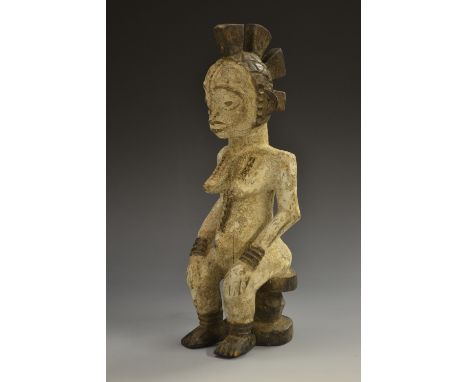Tribal Art - an African fertility figure, seated on a stool, white pigment, 23cm high 