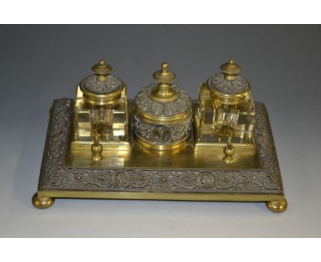 A 19th century gilt brass and electrotype rectangular standish, central cylindrical wafer box flanked by a pair of square gla