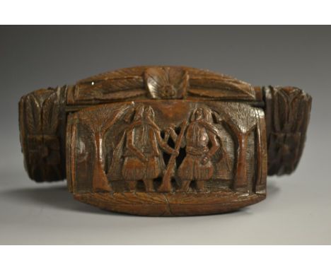 A late 18th century coquilla nut snuff box, carved with bearded soldiers, palm trees and stiff leaves, hinged cover, 8.5cm wi