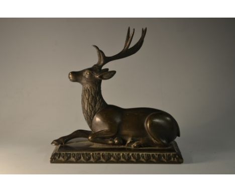 A dark patinated bronze model, of a recumbent stag, possibly Mughal and on a later stand, 13cm wide  