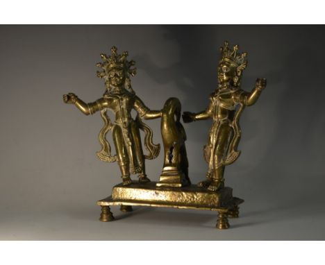A 19th century Indian bronze shrine group, cast as two deities beside a bird, rectangular base, stepped bun feet, 20cm wide