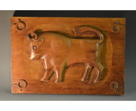 A folk art panel, naively carved in relief with a bull, 35cm wide