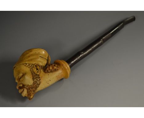 A 19th century Meerschaum pipe, the bowl carved as the head of a Nubian, wearing a fez, hawthorn shaft, 26cm long, c.1880