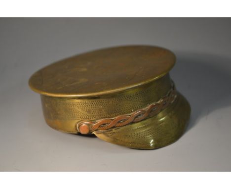 A World War I Trench Art brass novelty snuff box, as an officer's cap, hinged cover, decorated with wrigglework, inscribed So