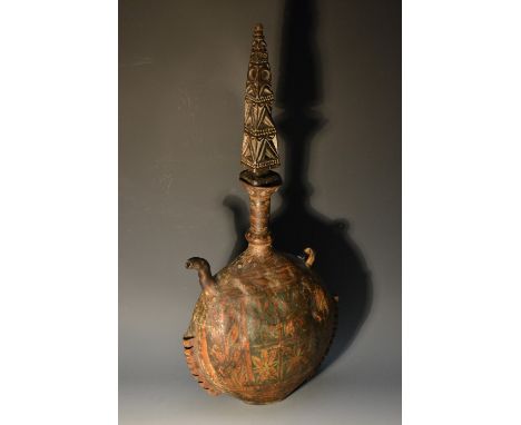 A South American globular hide flask and stopper, painted with flowerheads and foliage in tones of red, green and yellow pigm