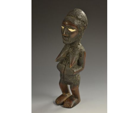 Tribal Art - an African fertility figure, of phallic form, she stands, her hands on her swollen belly, inlaid eyes, 22cm high