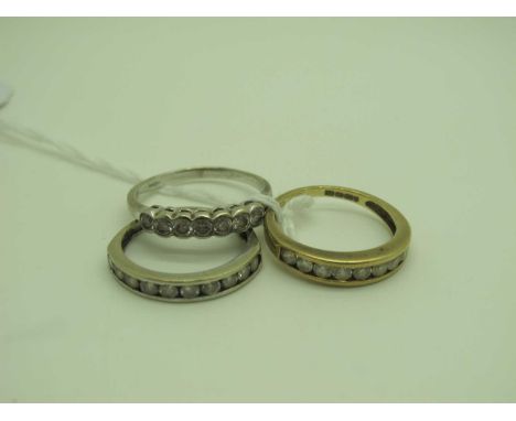 A CZ Set Half Eternity Ring, stamped "375" (finger size N½), another similar, stamped "9K" (finge size O), and a seven stone 