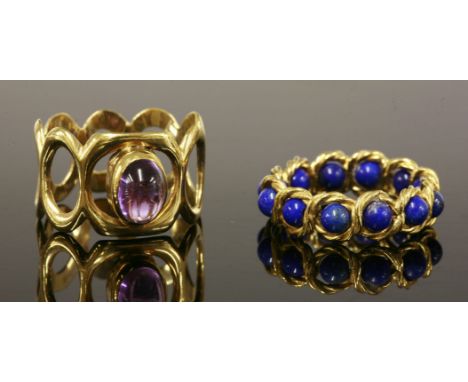 A single stone gold amethyst ring, c.1970,with an oval cabochon amethyst, rub set to a plain collet, mounted to a wide band o