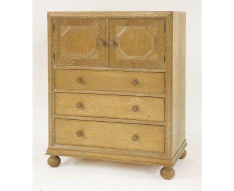 An oak cupboard chest,probably by Greenings of Oxford for Heal's, of small proportions, with a pair of octagonal panelled doo