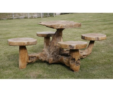 A contemporary hardwood table and stools,the table carved from a single trunk with four fixed stools,180cm wide overall77cm h