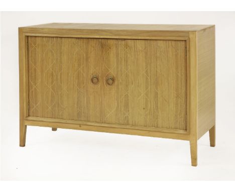 An Helix sideboard,designed by David Booth for Gordon Russell, retailed by Heal's, the routed cupboard opening to reveal a sh