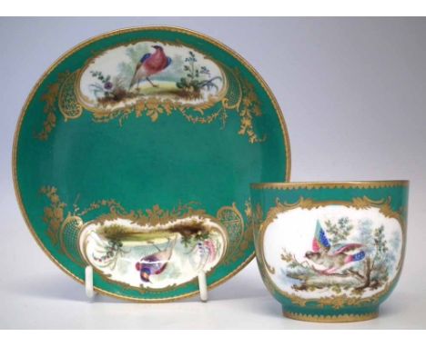 Sevres cup and saucer, painted with exotic birds within gilded cartouches on a green ground, painted marks to bases, late 18t