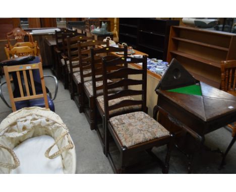 An oak gate leg dining table with a set of six ladder back chairs to include two carvers