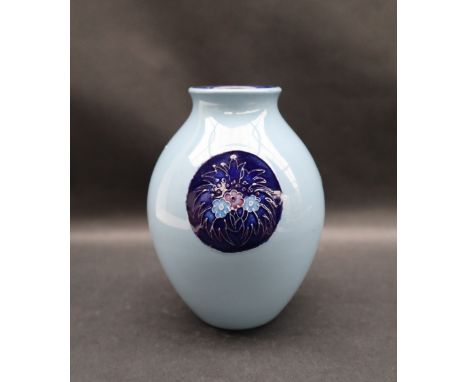 A Moorcroft pottery vase decorated with royal blue vignettes of flowers and leaves to a light blue ground, impressed mark, Tr