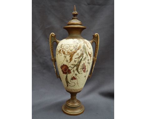 A Royal Worcester porcelain twin handled vase and cover, decorated with flowerheads and leaves to an ivory ground, on a sprea