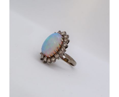 An opal and diamond ring, the central oval opal, chipped, surrounded by round brilliant cut diamonds to an 18ct white gold se