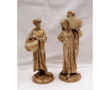 A pair of Royal Worcester figures of water carriers, No.1250, in an ivory body colour with gilt highlights, 22cm high, puce m