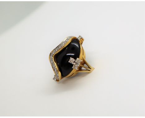 A diamond and cabochon onyx dress ring, set with seventeen diamonds to a yellow metal setting and shank, size N, approximatel