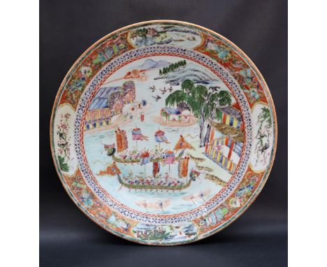 A Chinese porcelain charger the centre painted with Dragon head boats, with mountains and trees in the background, the border