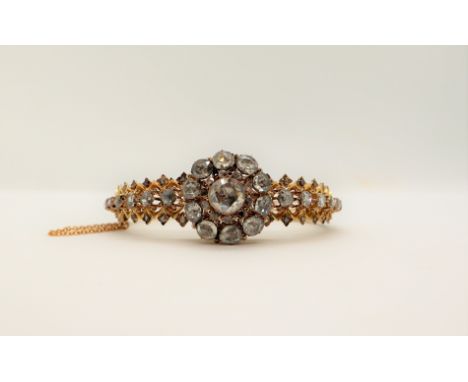 A Victorian diamond encrusted hinged bangle, set with rose cut diamonds to a yellow metal setting, approximately 34 grams, ca