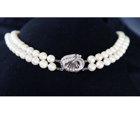 A double strand pearl necklace set with one hundred and twenty one regular pearls to a white metal fan shaped diamond set cla