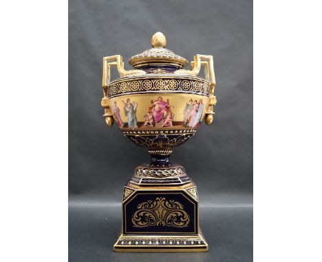 A Vienna twin handled vase and cover, painted with groups of figures to a gilt background and royal blue ground on a rectangu