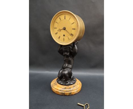 An early 19th century English gilt drum clock, the drum supported by a spelter cherub on a marble plinth, the movement signed