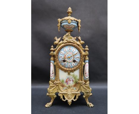 A 19th century French ormolu clock with a porcelain urn surmount, the porcelain dial with wreath of flowers and Roman numeral