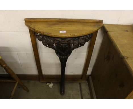 An oak and cast iron console table with ram's head decoration