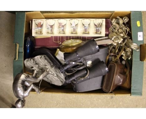 A box of miscellaneous items including binoculars, camera, model of a skier, boxed glasses etc.