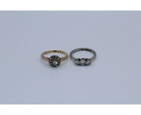 Two early 20th century diamond rings, a diamond cluster daisy ring, stamped18 to the shank, size K1/2, along with a three sto