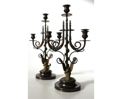 A pair of late 19th century ormolu and brass Eagle and Snake three light table candlesticks, applied with stiff leaves, raise