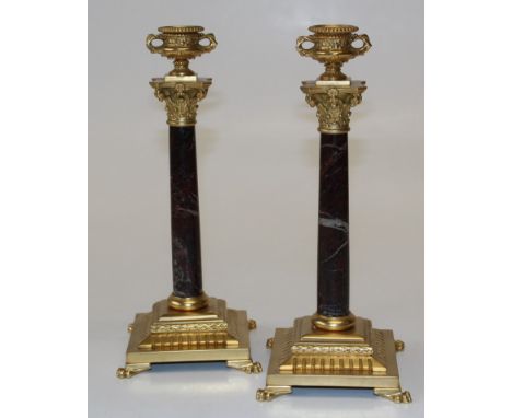 A pair of neoclassical style gilt bronze and marble candlesticks, each with a twin handled urn form sconce with beaded rim, o