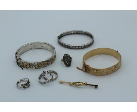 A collection of jewellery comprising a Victorian aesthetic movement bangle, a Greek key silver bangle with atching ear hoops,