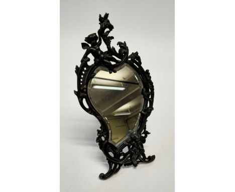 A 20th century bronze Rococo easel toilet mirror, cast with cherubs, after Paul LeCourtier, 40cm length