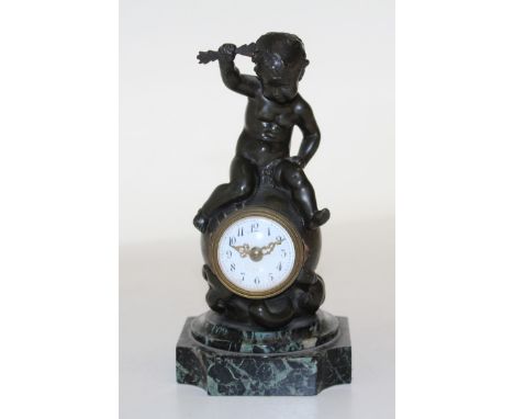  A French bronze desk clock, signed H. Capy, in the form of a putto sat atop a globe, his hand aloft grasping a sprig of leav