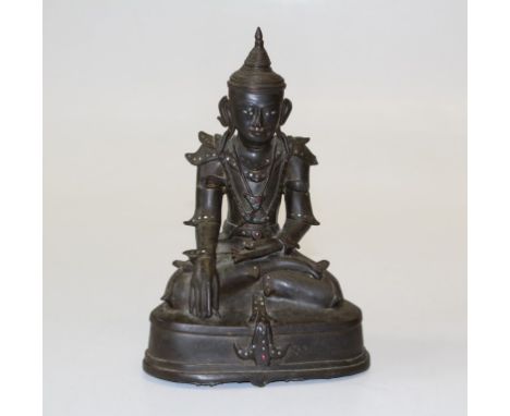 A Thai bronze Buddha, probably late 17th century. Seated in typical pose, with shell eyes and coloured glass bead detail. Tra