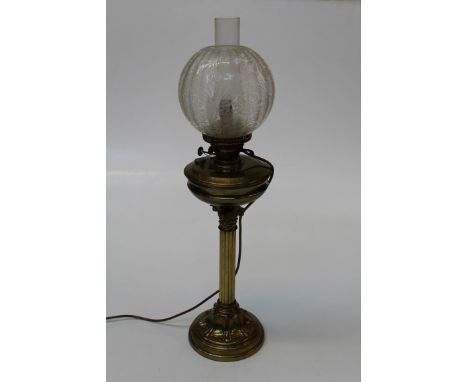 An Edwardian paraffin table lamp with brass reservoir, Corinthian column and swept panel cast circular base. Converted for el
