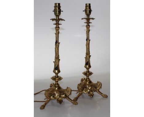  A pair of French gilt bronze table lamps, of scrolling foliate form, 20th century, with leaf form drip trays over a tapering