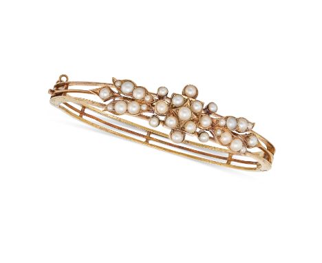 AN ANTIQUE VICTORIAN PEARL BANGLE in yellow gold, the openwork hinged bangle set with pearls in a foliate design, no assay ma