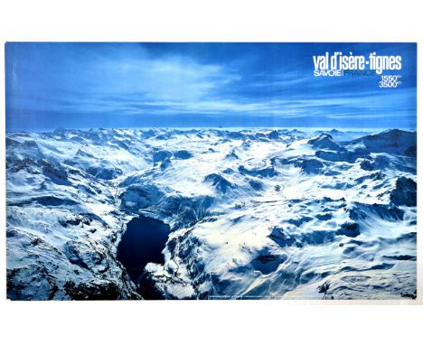 Original vintage ski poster for Val d'isere-tignes featuring a great photo of a wide snowy mountain range with a lake in the 