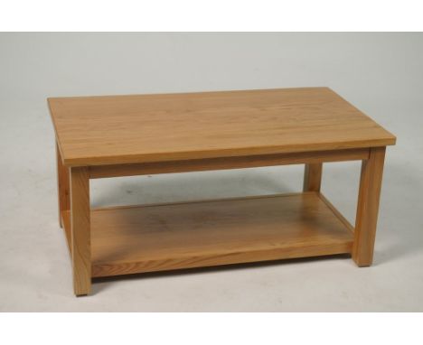 A modern light oak coffee tableWith a rectangular top raised on four square section supports with a rectangular under shelf, 