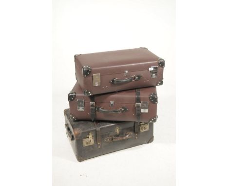 A Collection of three vintage suitcases To include a large black leather suitcase, with painted initials M.M,N.B, together wi