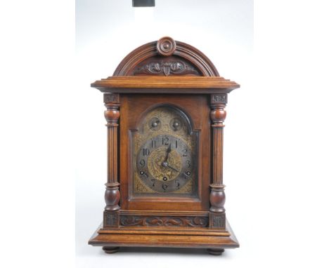 A 19th Century German chiming bracket clockThe stained oak case of architectural form with arched cresting and flanked by Cor