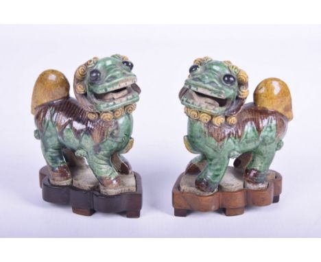 A pair of Chinese Sancai glazed lion dogs, probably Kangxi period (1662 - 1722)Each modelled in relief and in standing positi